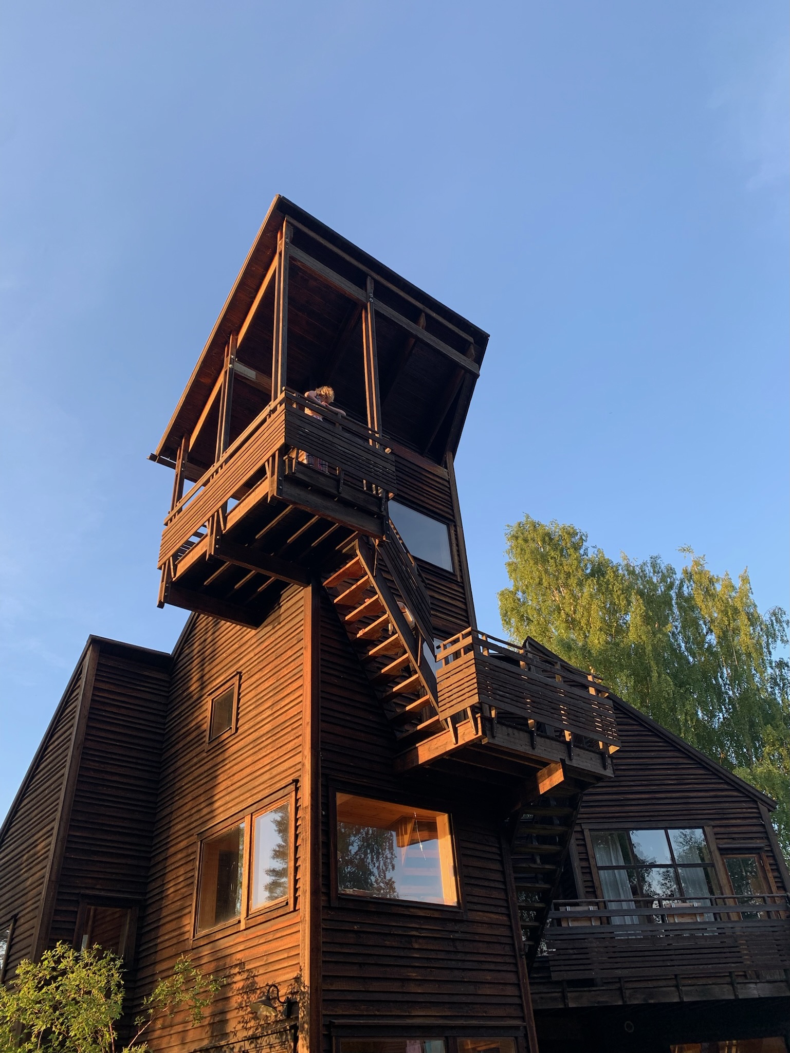 Träbyggnad med utskjutande tak och balkong på Skaparbyn