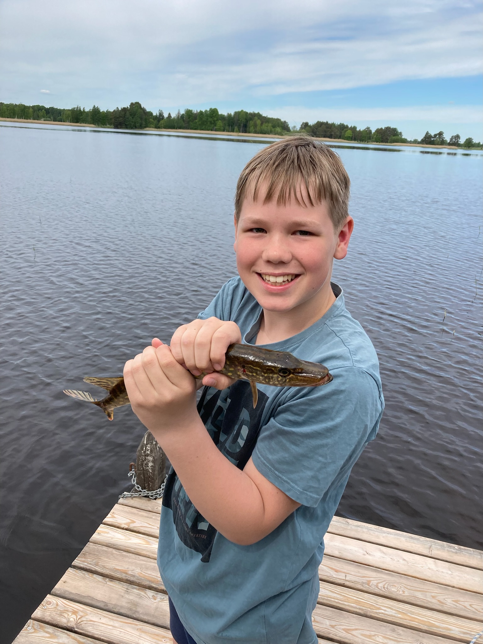 En deltagare visar en fångad fisk på bryggan