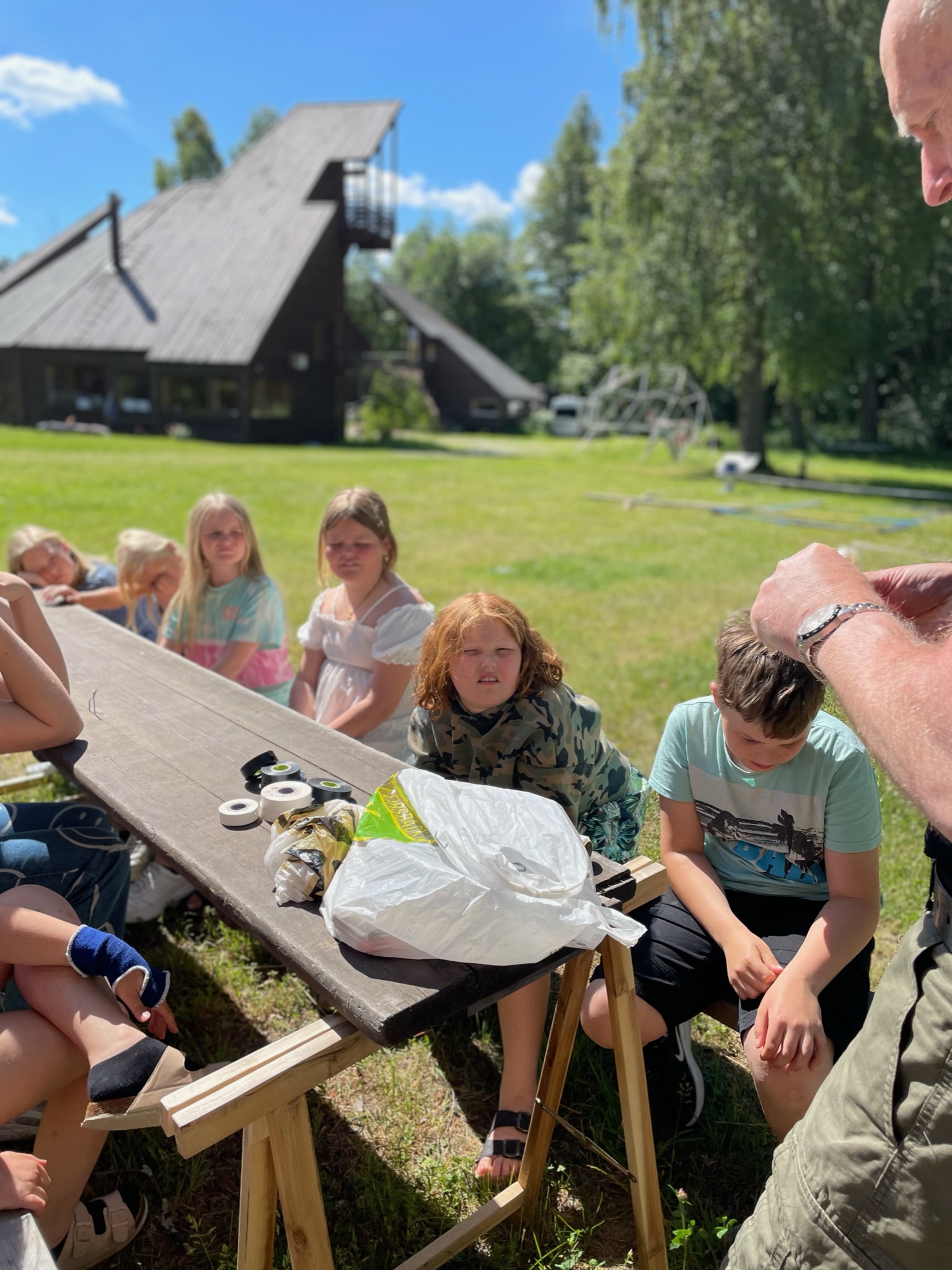Deltagare ser på en demonstration vid ett bord utomhus