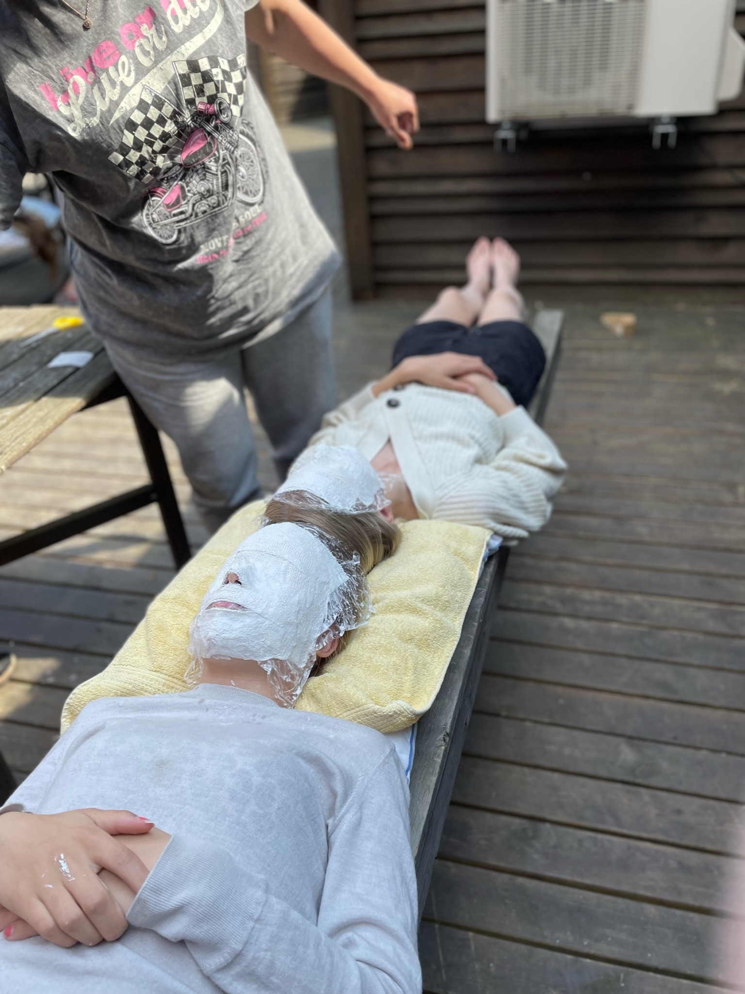 En ansiktsmask av gips formas på en deltagare utomhus